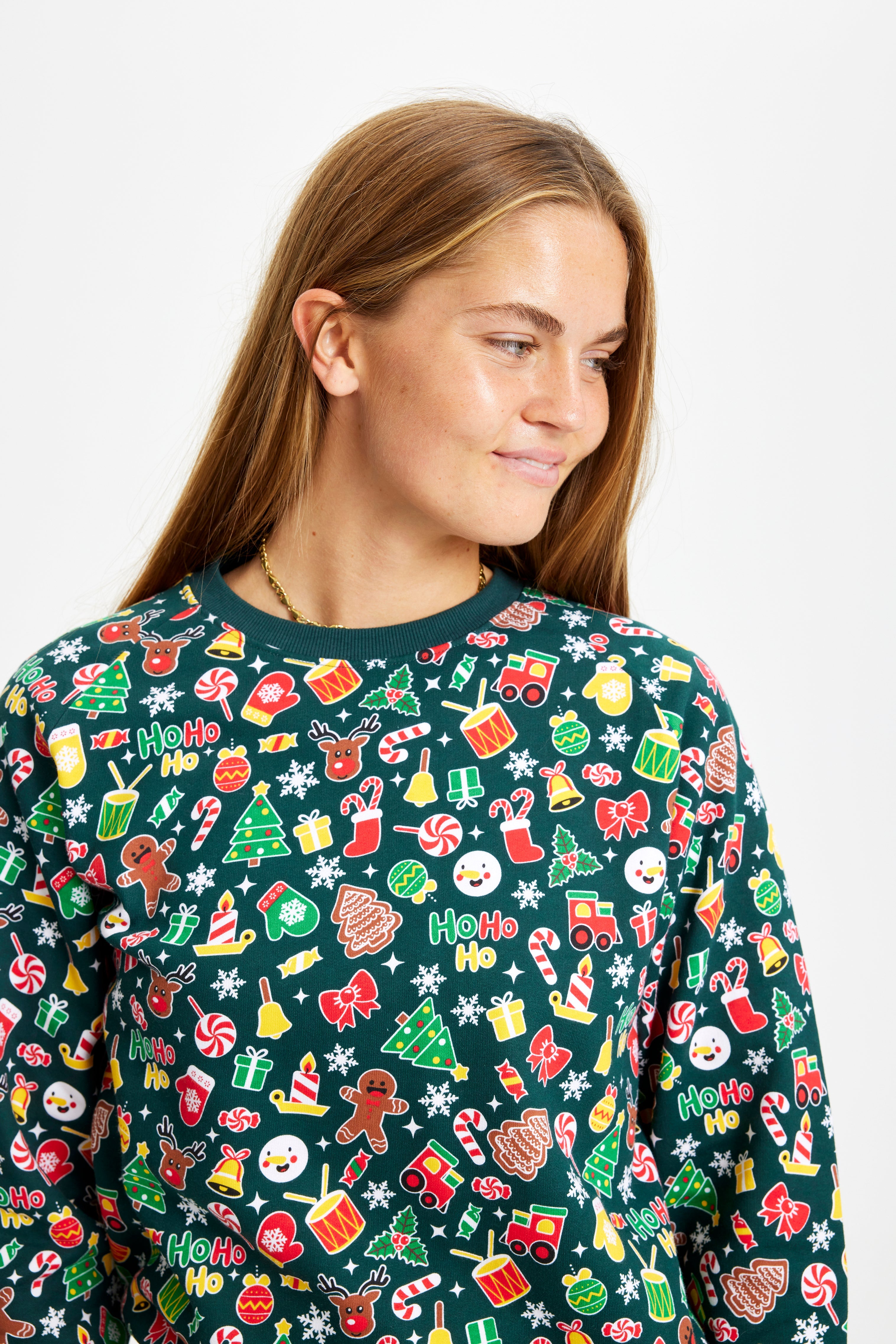 En dame kigger ned og har en grøn julesweater på.